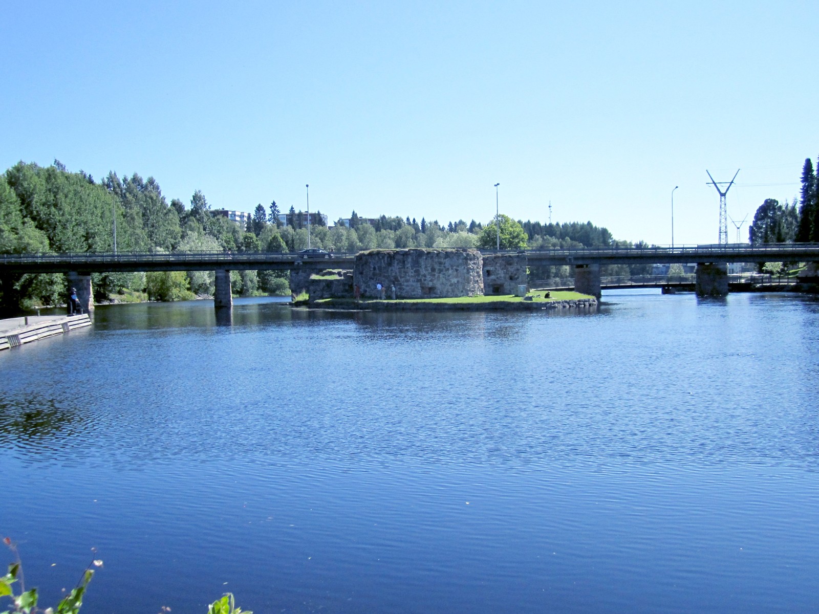 Kuvituskuva Kajaanista: linnanrauniot, silta ja Kajaaninjoki; ei kuva uimahallista.